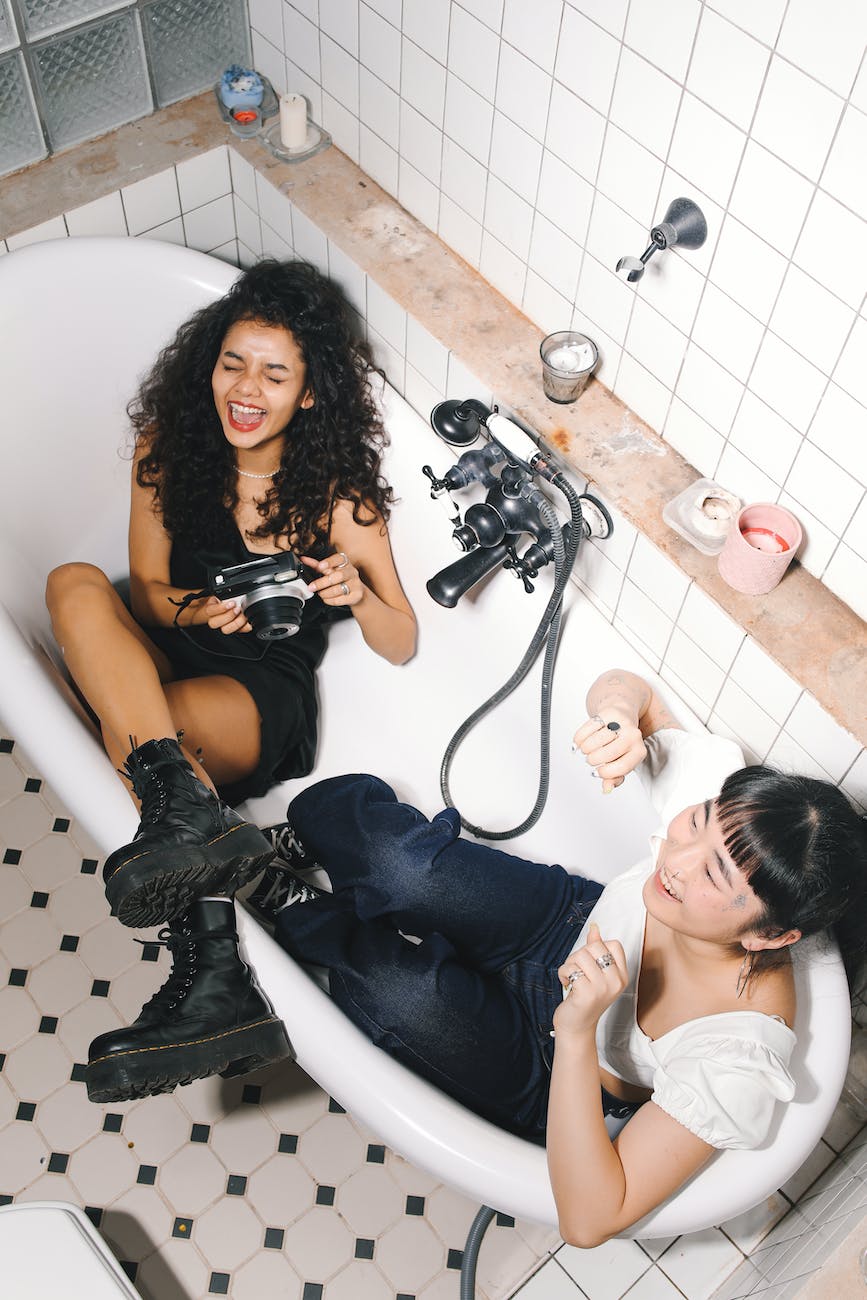 laughing friends sitting inside a bathtub